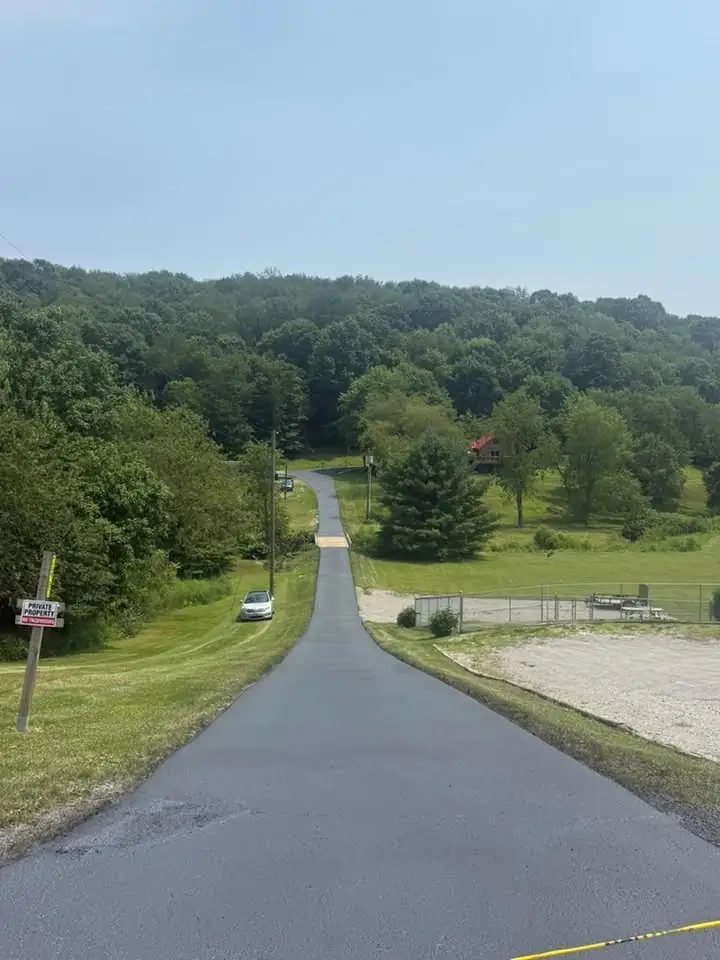 A long freshly sealed country driveway running down a hill in Columbiana County, Ohio