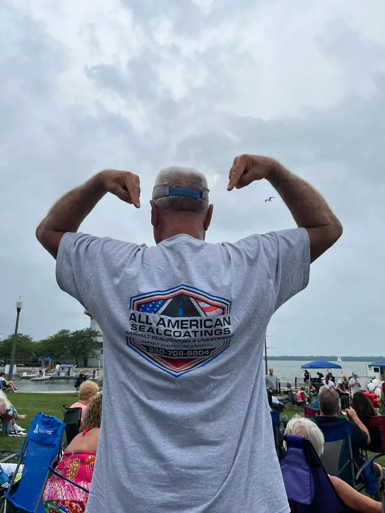 The owner of All American Sealcoatings wearing a company shirt at a local waterfront event